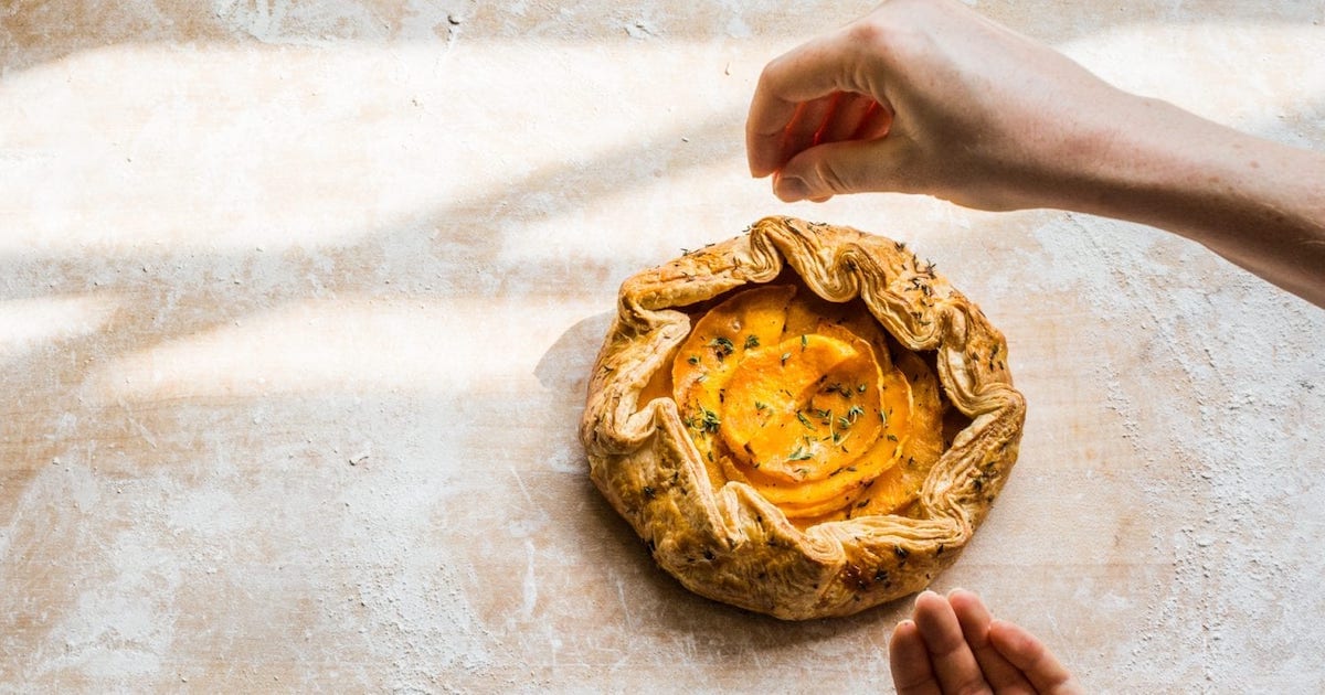 A hand seasoning a butternut squash galette, one of our most elegant butternut squash recipes