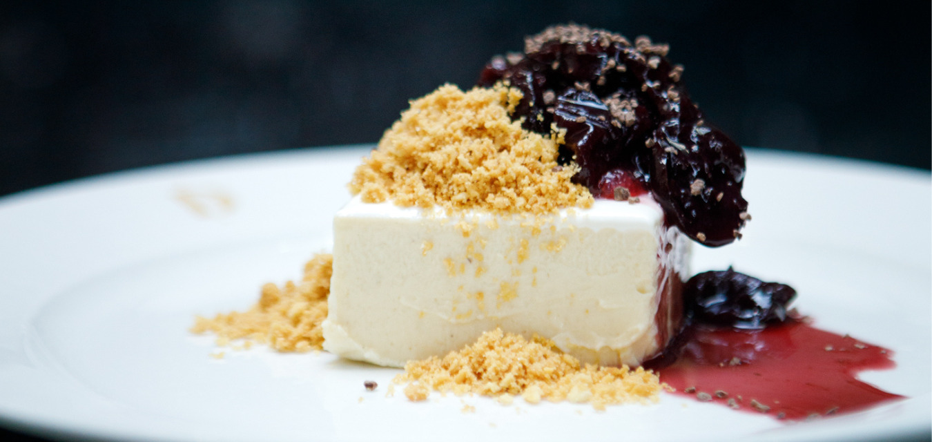 Slice of cherry cheesecake topped with saltine crumble and cherry compote