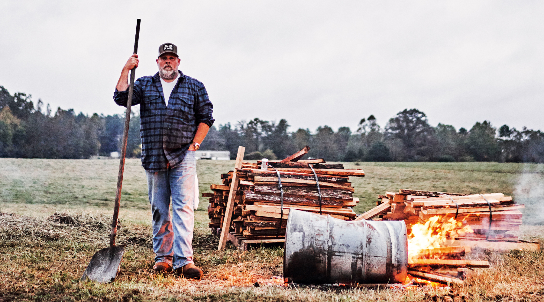 Pitmaster Pat Martin in front of a smoker in an open field in Tennessee.