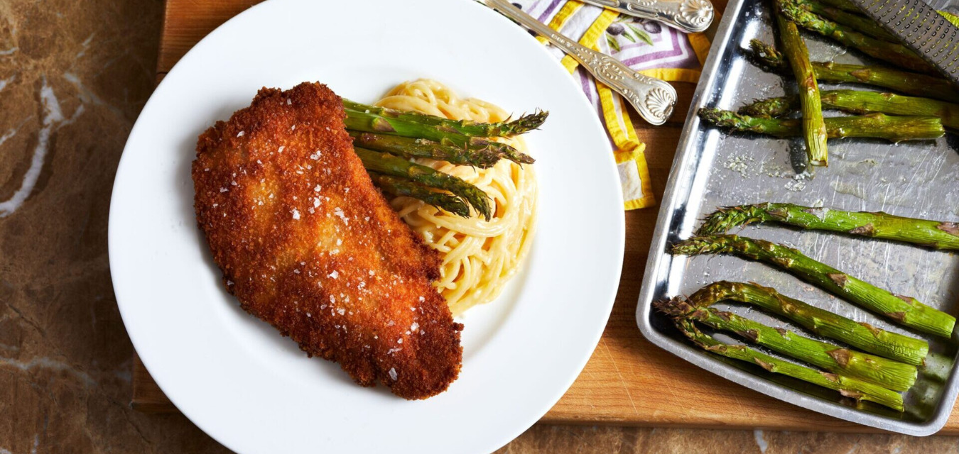 Pan fried pork chop plated with spaghetti aglio e olio and roasted asparagus, one of our most popular November recipes
