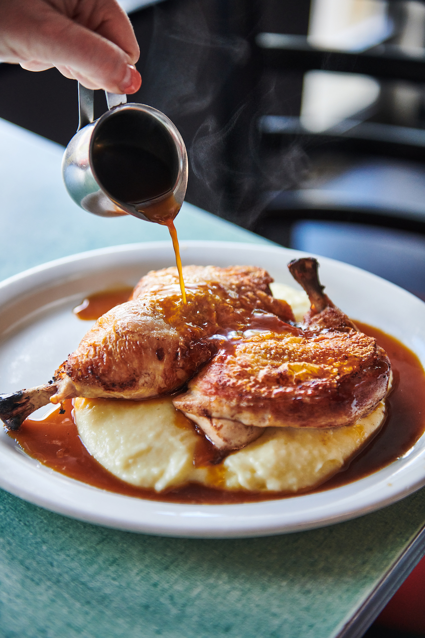 Pouring gravy over chicken over mashed potatoes at Poole's Diner