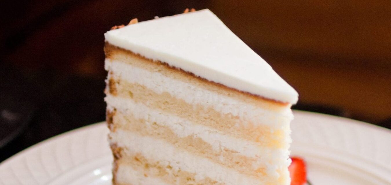 Peninsula Grill's Ultimate Coconut Cake with strawberries on plate