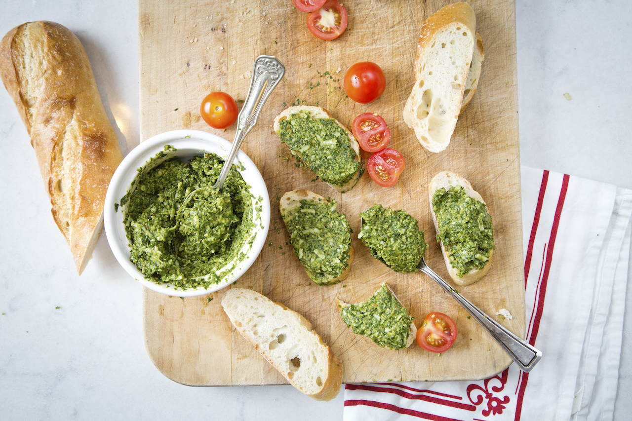 Pesto on board with cherry tomatoes and baguette