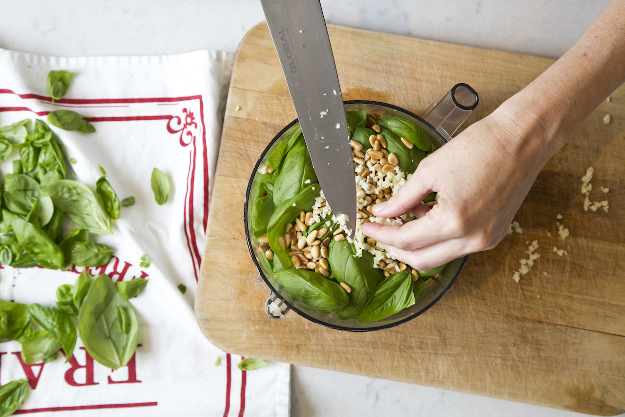 Adding basil and garlic to a food processor