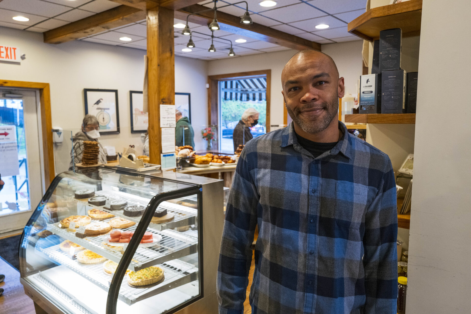 Owner standing proudly in front of beautiful pastry case