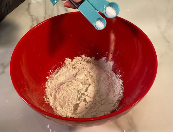 Adding dry ingredients to the Detroit style pizza dough