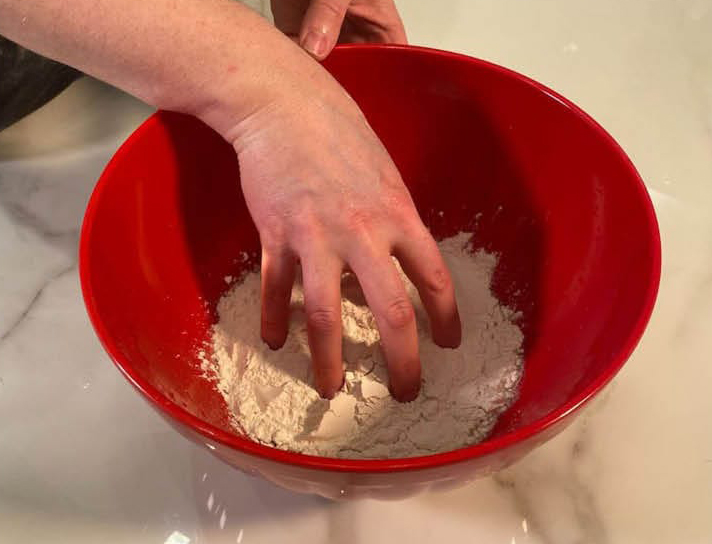 Adding dry ingredients to Detroit-style pizza dough