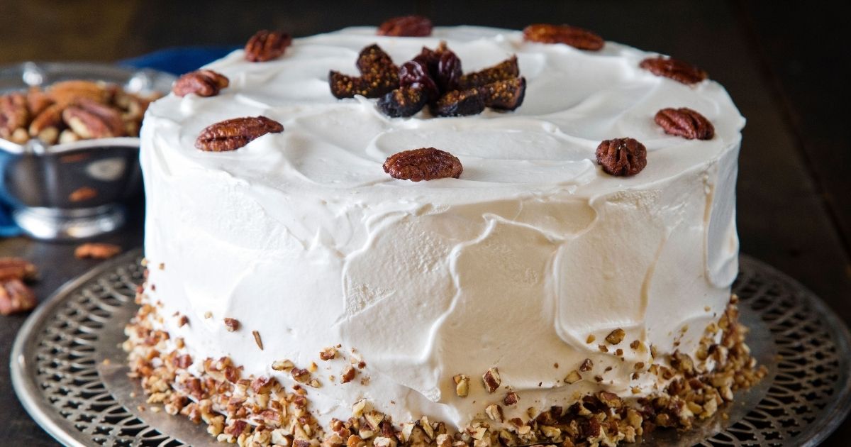 Whole hummingbird cake on a cake plate for an Easter dessert.