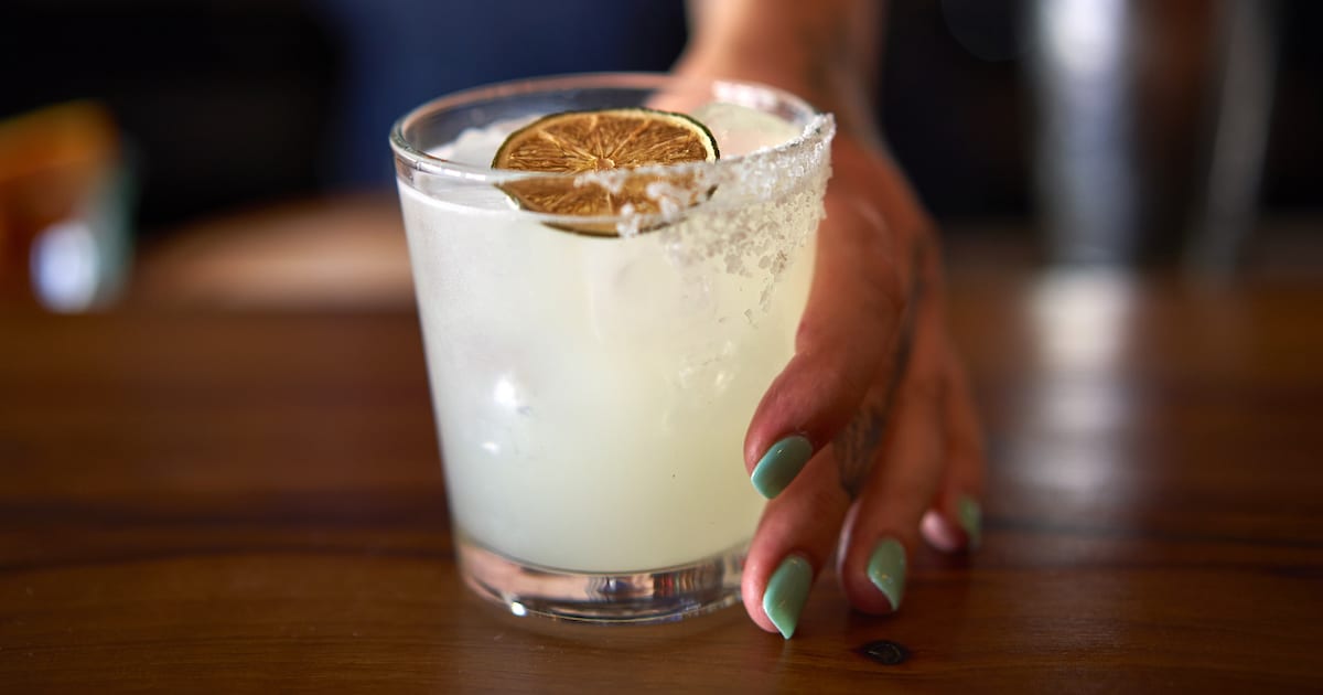 A hand holding the Las Almas classic simple syrup margarita