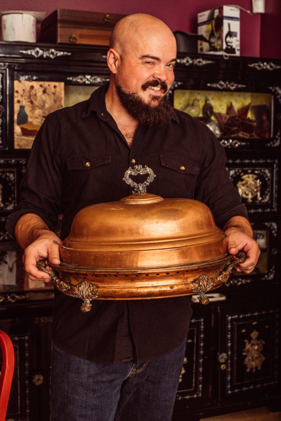 Isaac Toups with a large pot, serving his cajun christmas
