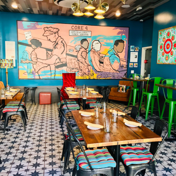 Tables and a painting at Bésame, one of the new restaurants in Louisiana