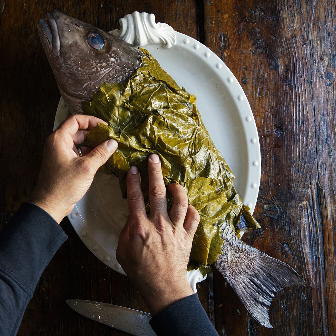 Whole snapper wrapped in grape leaves for a Hanukkah main dish