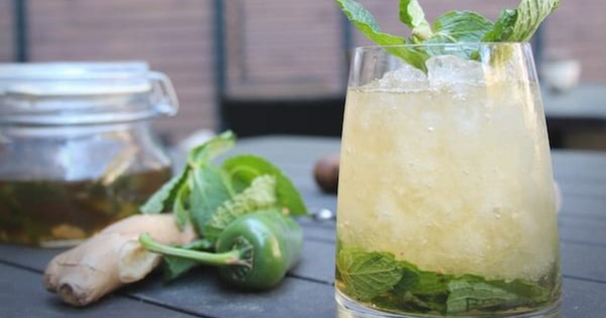 The hot julep in a stemless wine glass with jalapeno and mint