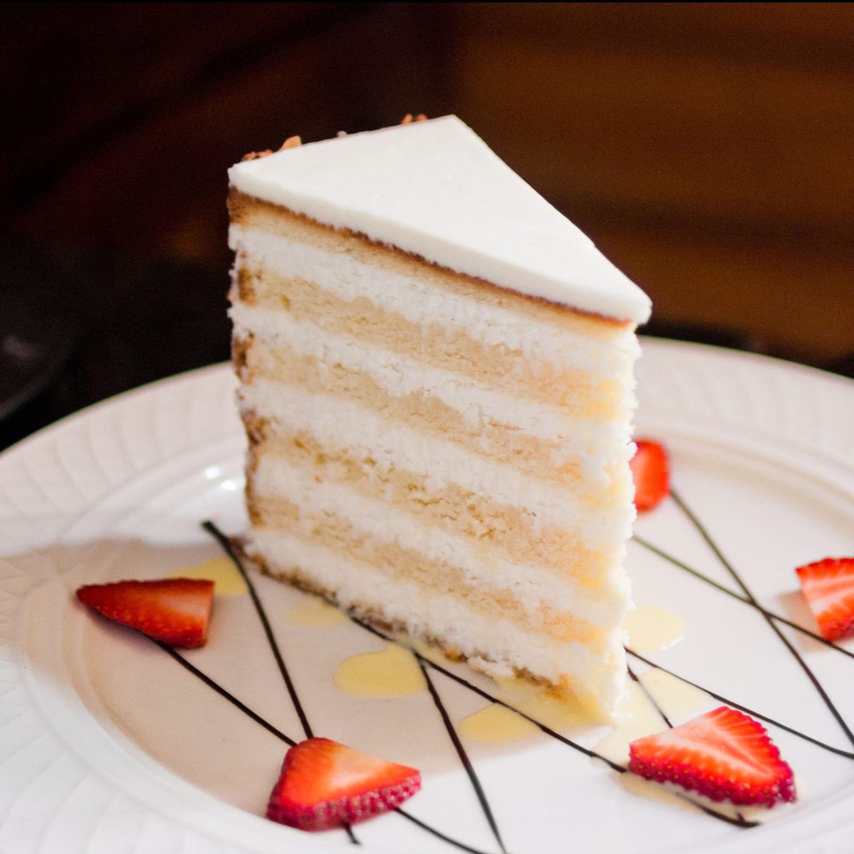 Peninsula Grill's Ultimate Coconut Cake with strawberries on plate