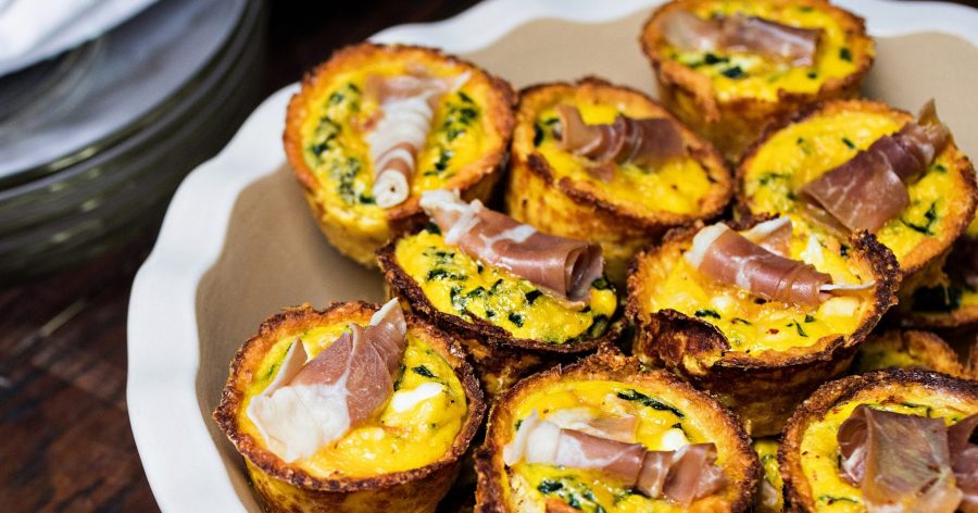 Platter of mini quiches made with spinach, feta, and prosciutto