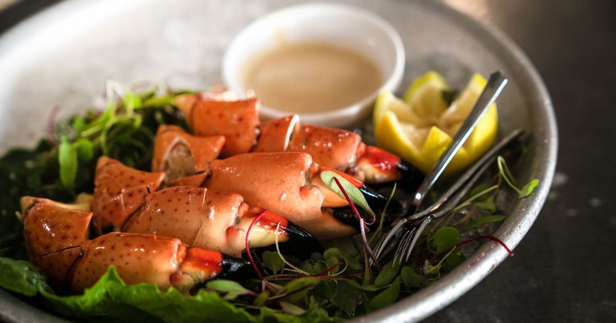 Florida-caught stone crab served with mustard sauce and lemon wedges