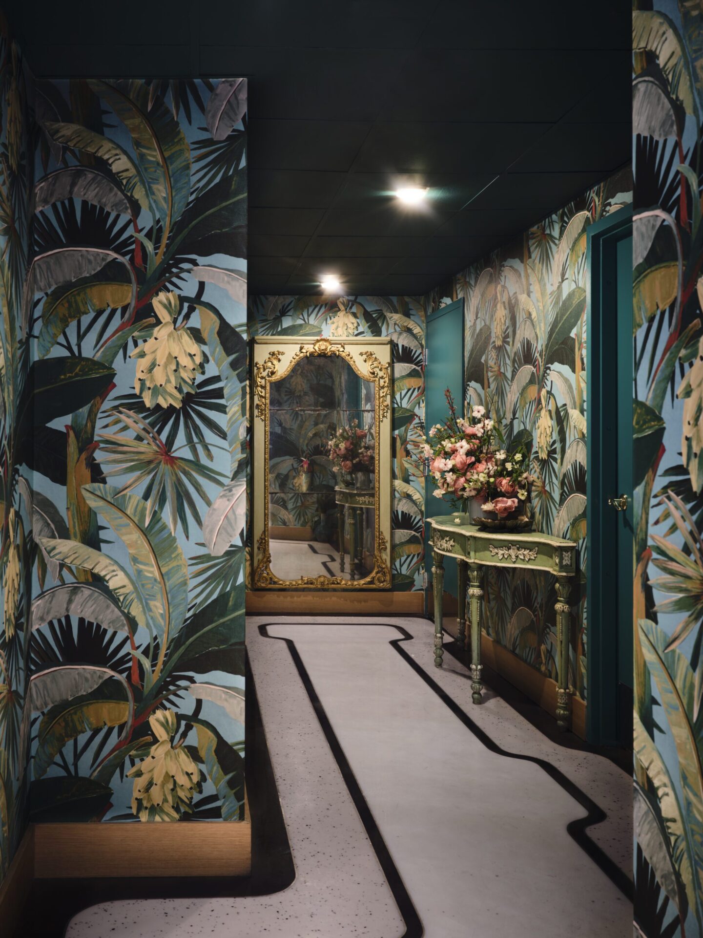 Photograph of the inside of ZZ's Club in Miami with palm tree wall paper and gold mirror. 