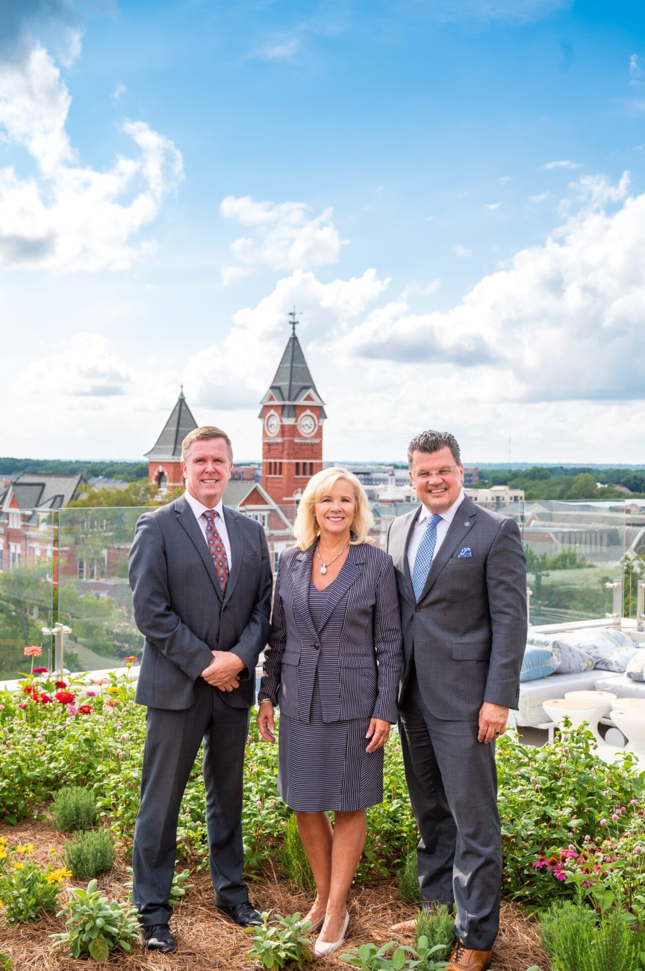 Photograph of three people standing on the roof the Lauren Hotel and Spa overlooking Auburn University 