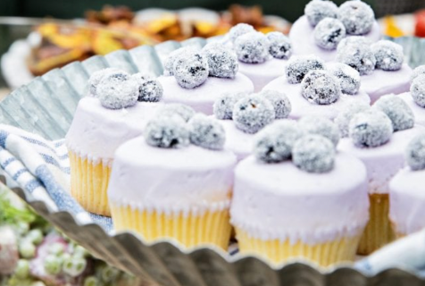 Photograph of purple cupcakes sitting on a platter from a bakery