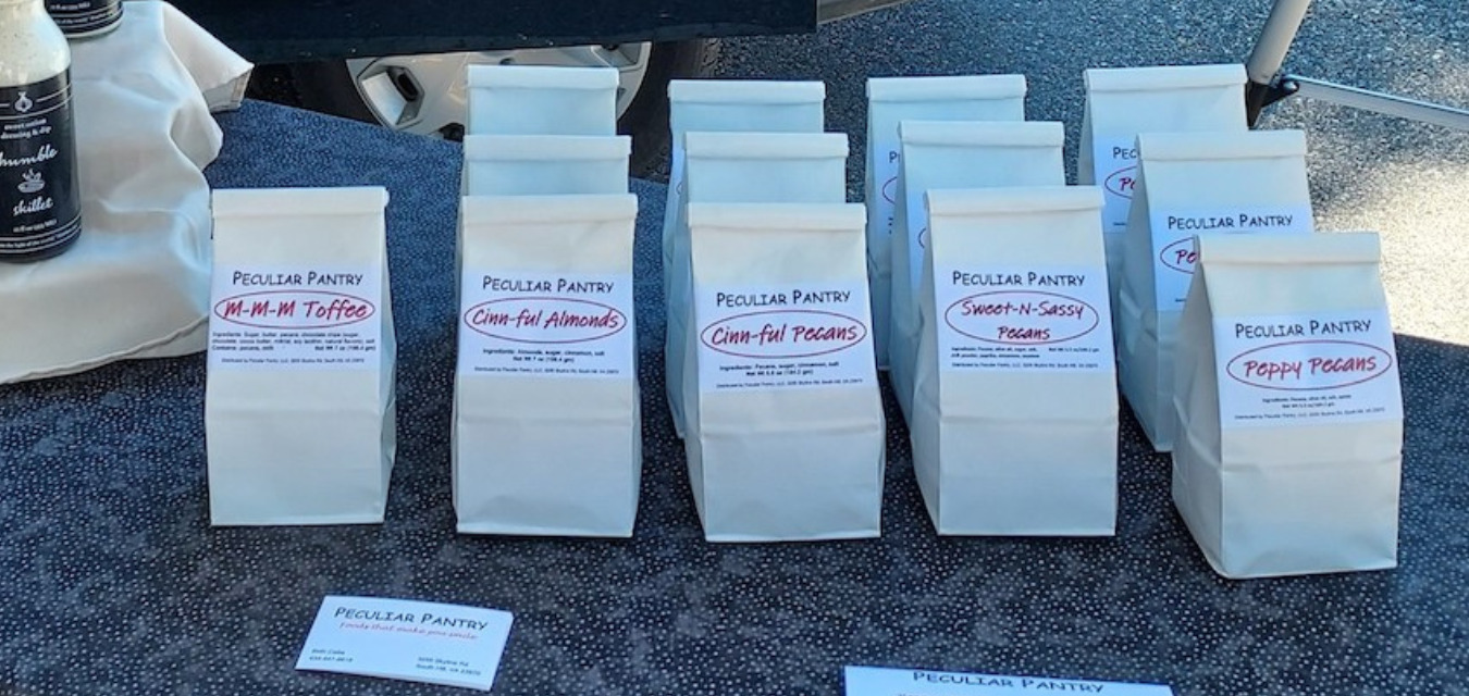 Bags of Peculiar Pantry seasoned nuts arranged at the South Hill Makers Market