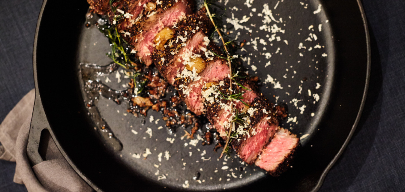 Skillet seared new york strip, sliced and garnished with rosemary and flaky sea salt