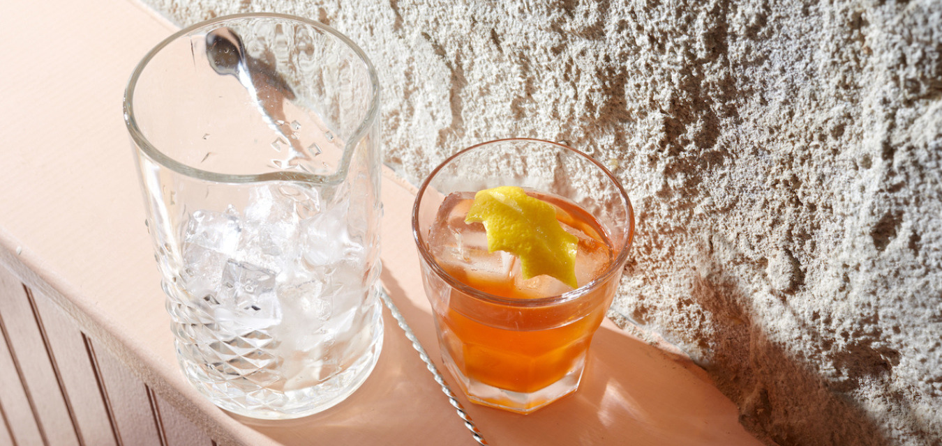 Kimberly Patton-Bragg’s Hot Toddy Old Fashioned in a glass beside a pitcher of ice