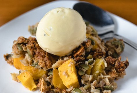 A plate of mango cranberry crisp with ice cream on top is a holiday baking project from Claudia Martinez