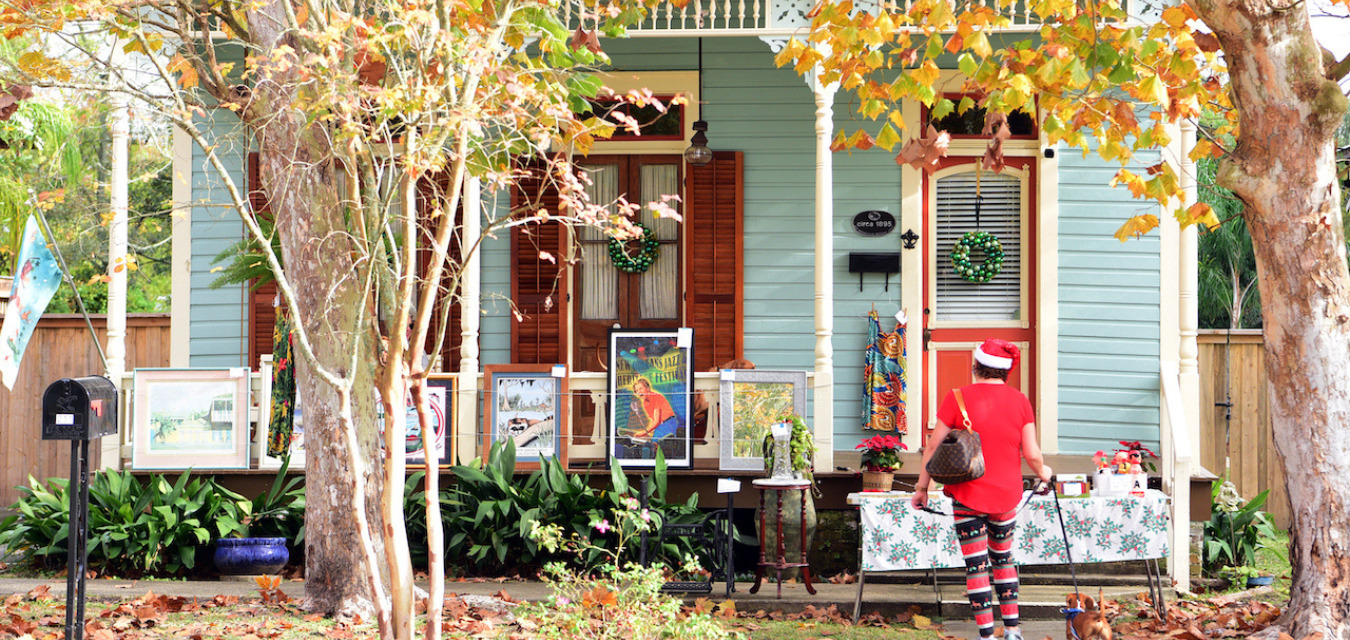 Front porch displaying large, framed artwork during the Old Mandeville Shop Local Saturday art market event on Girod Street in Louisiana Northshore