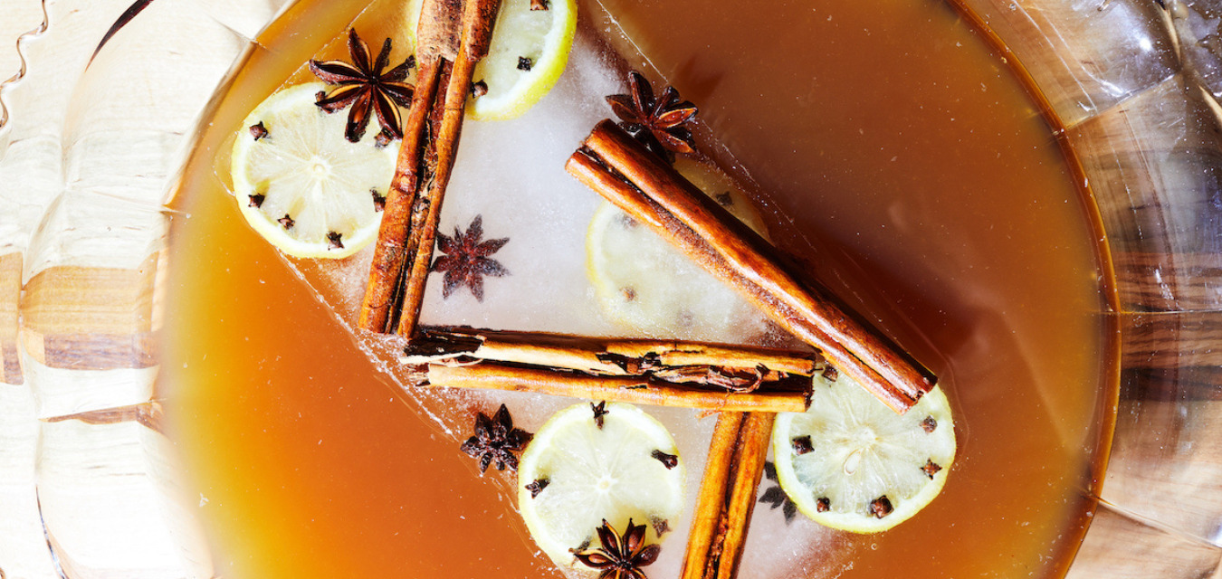 Kimberly Patton-Bragg’s Christmas cocktail The Gingerman Can, a holiday hot toddy, in a punch bowl with a brick of ice and garnished with star anise, clove-studded lemons, and cinnamon sticks