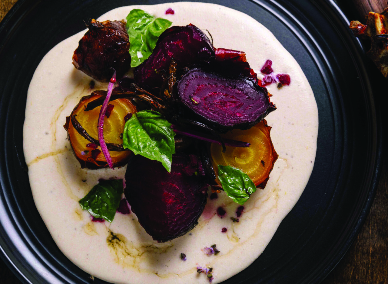 A plate of charred beets over goat cheese with honey, from Ilda