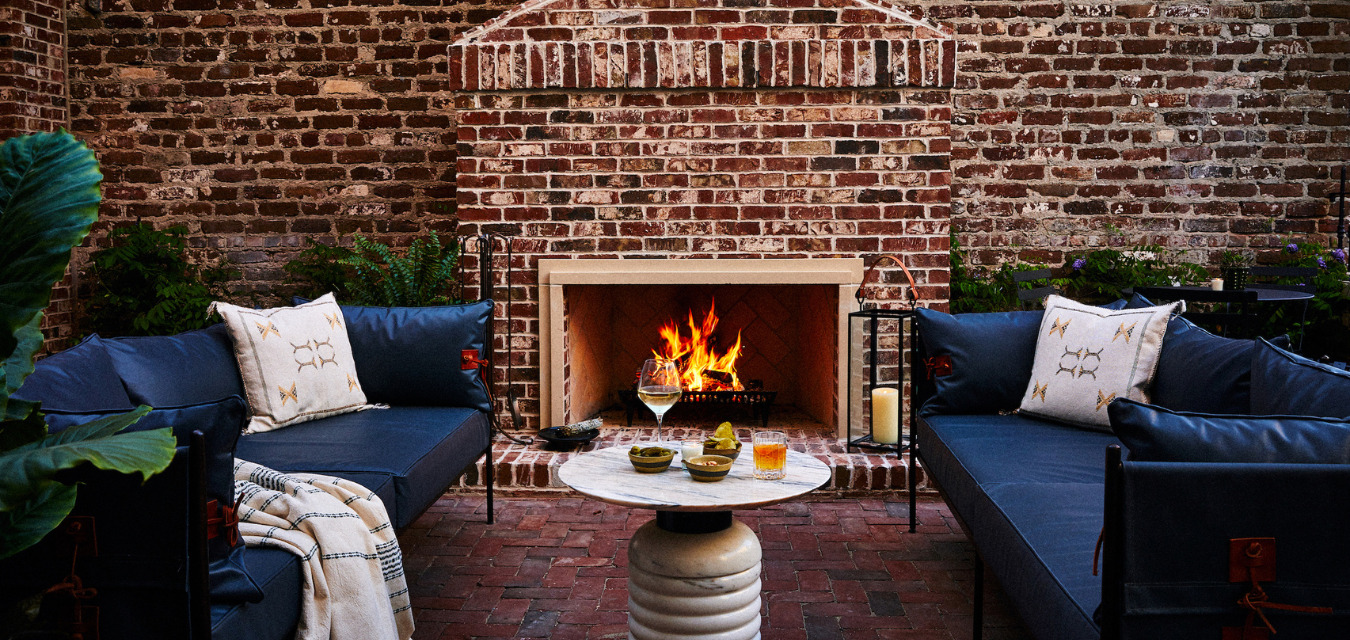 Blue cushioned sofas outside of the roaring fireplace at the Pinch Hotel in Charleston