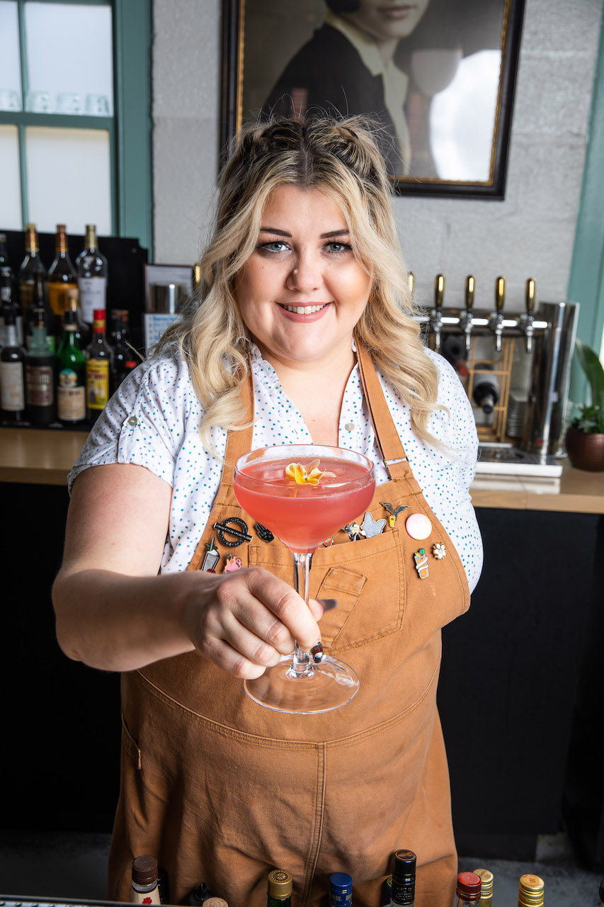 Haley Teague holds a spring cocktail, Elevation, at the bar at Hathorne