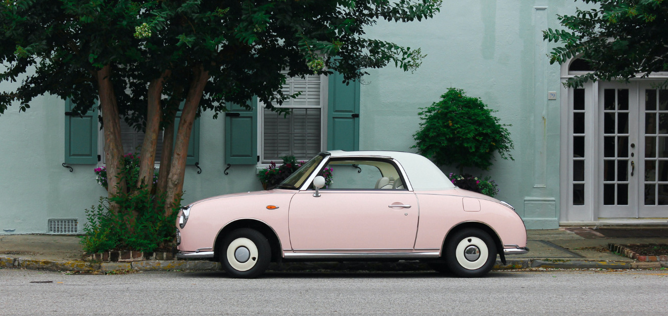 Downtown Charleston Featured Image: a vintage pink car against a seafoam green building