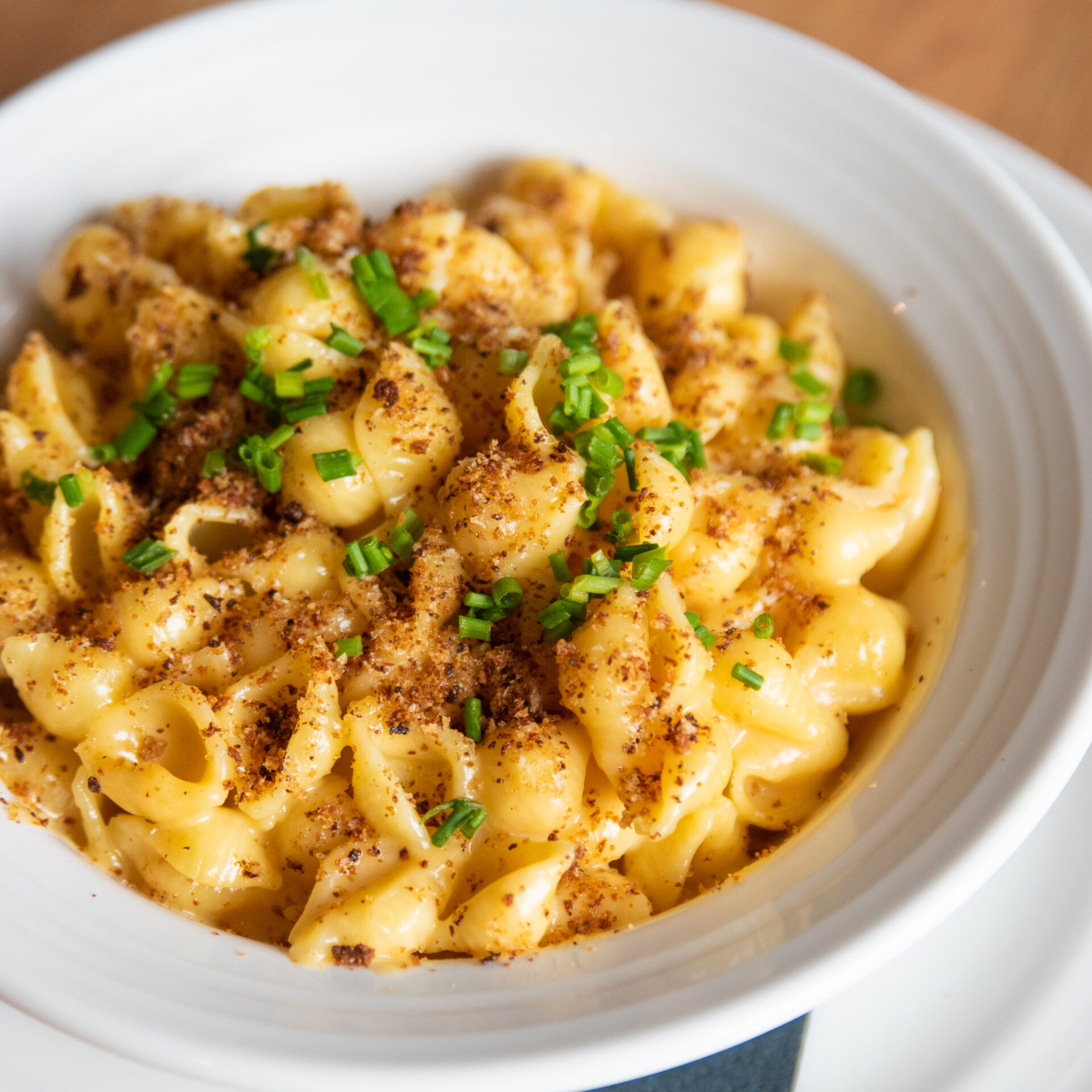 mac n cheese recipe showing mac n cheese in a bowl with spices and herbs on top