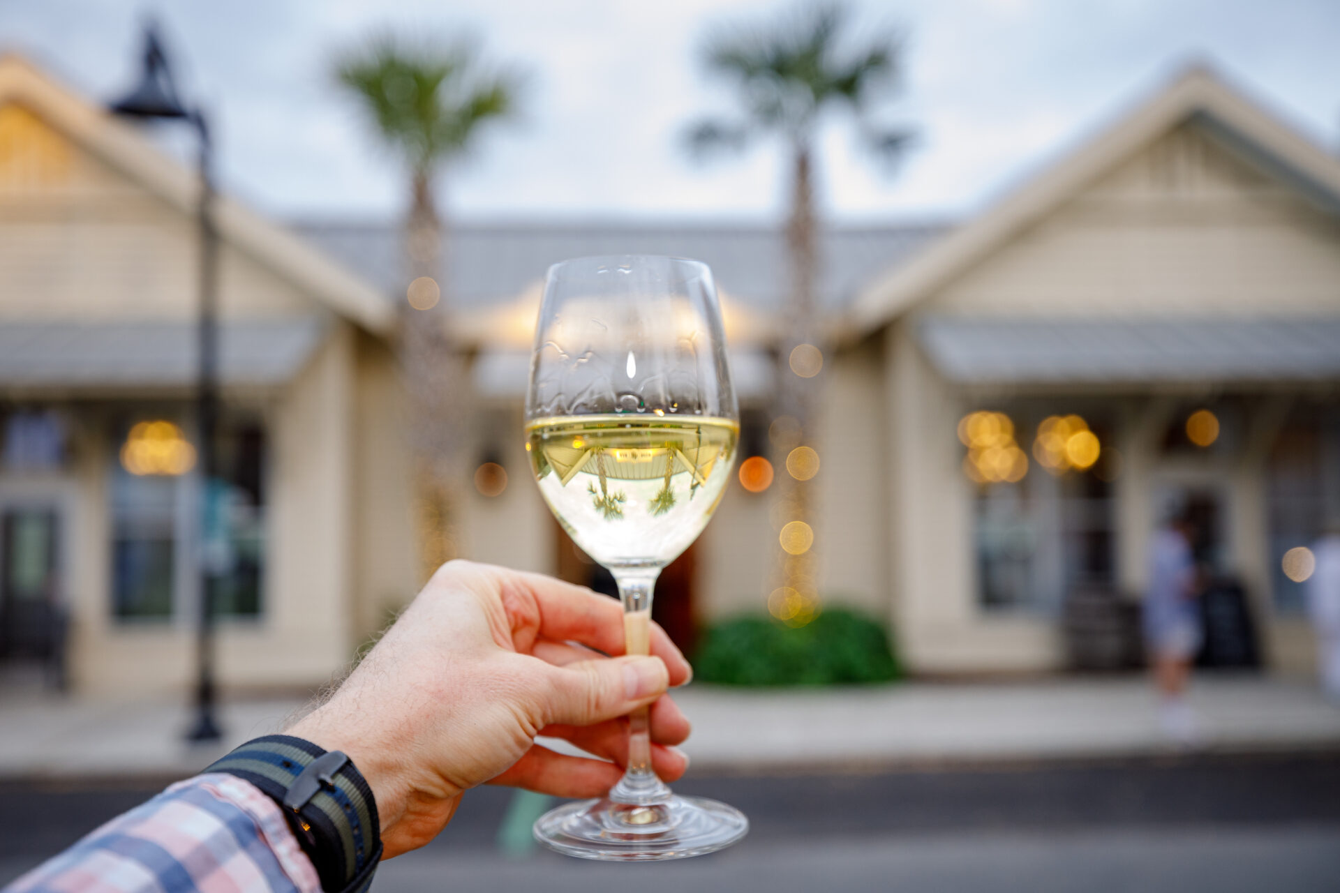 A glass of white wine held outside 48 Wine Bar on Johns Island, one of the sea islands