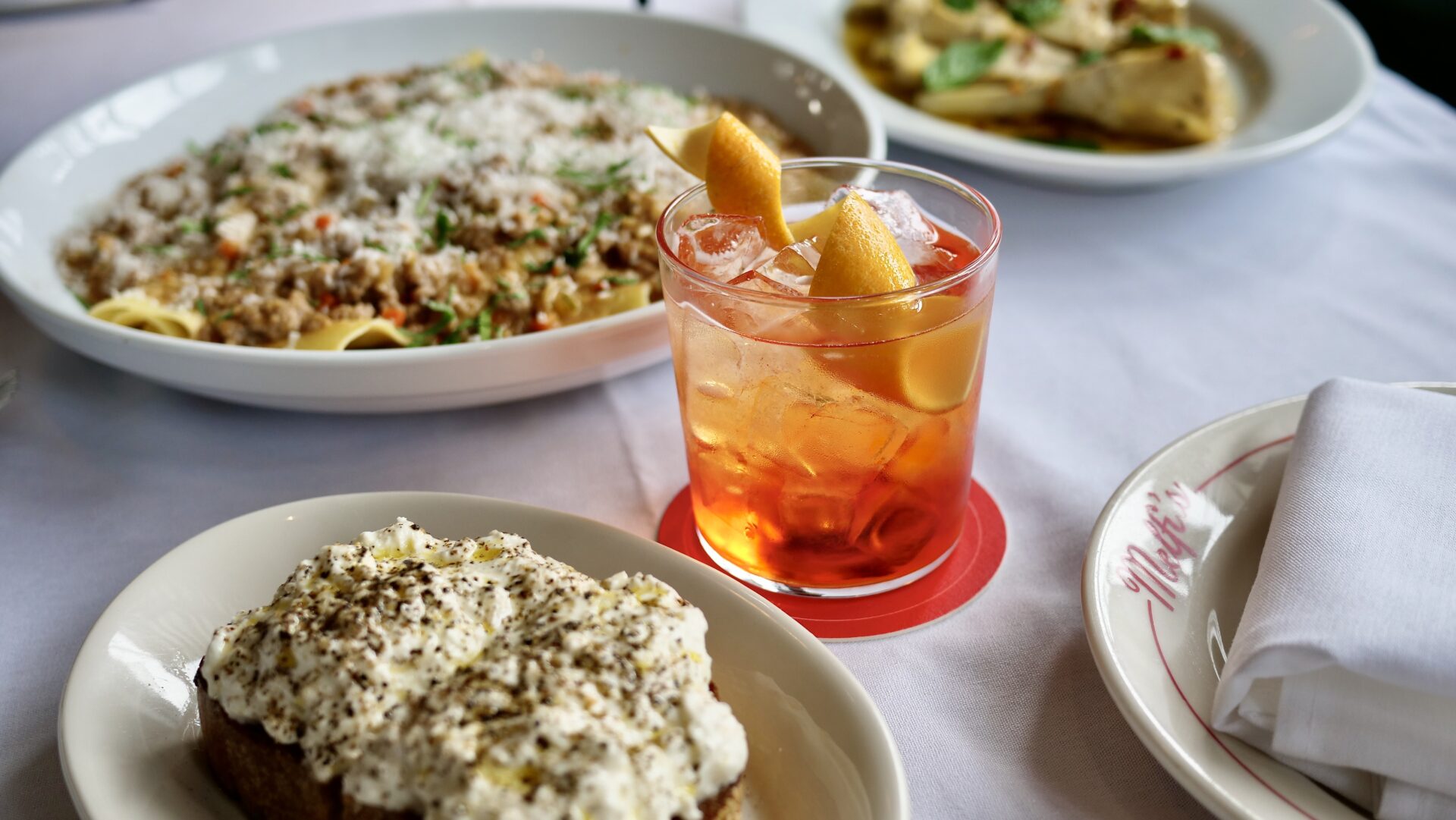A cocktail amidst plates of pasta at Melfi's in downtown Charleston