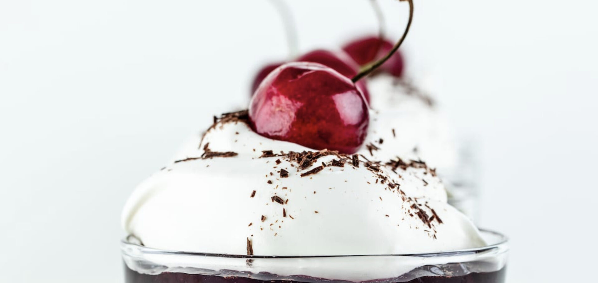 whipped cream and a cherry on top of chocolate cherry mousse cups, one of five no-bake desserts