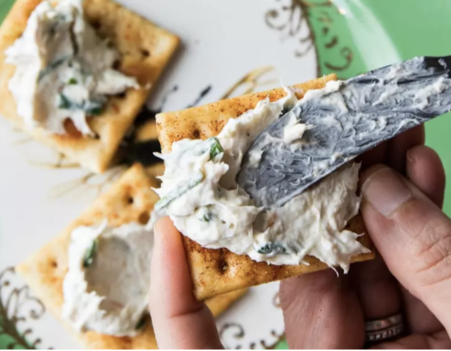Smoked Trout Dip being spread across a cracker, one of four Father's day ideas for meals