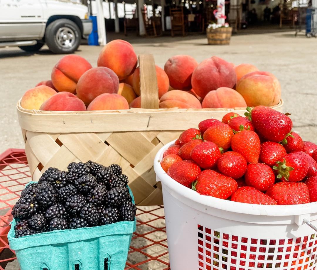 Market treats of strawberries, blueberries and peaches in buckets