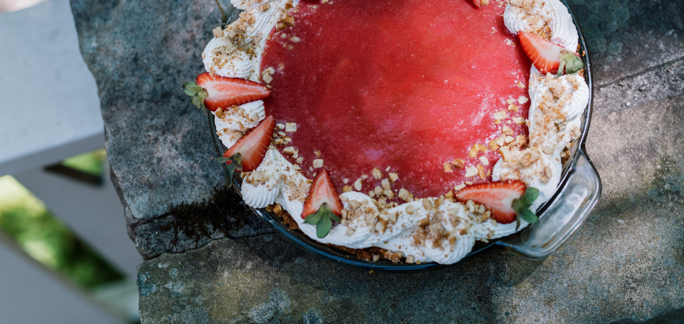A complete, whole Strawberry pretzel pie with strawberries and whipped cream