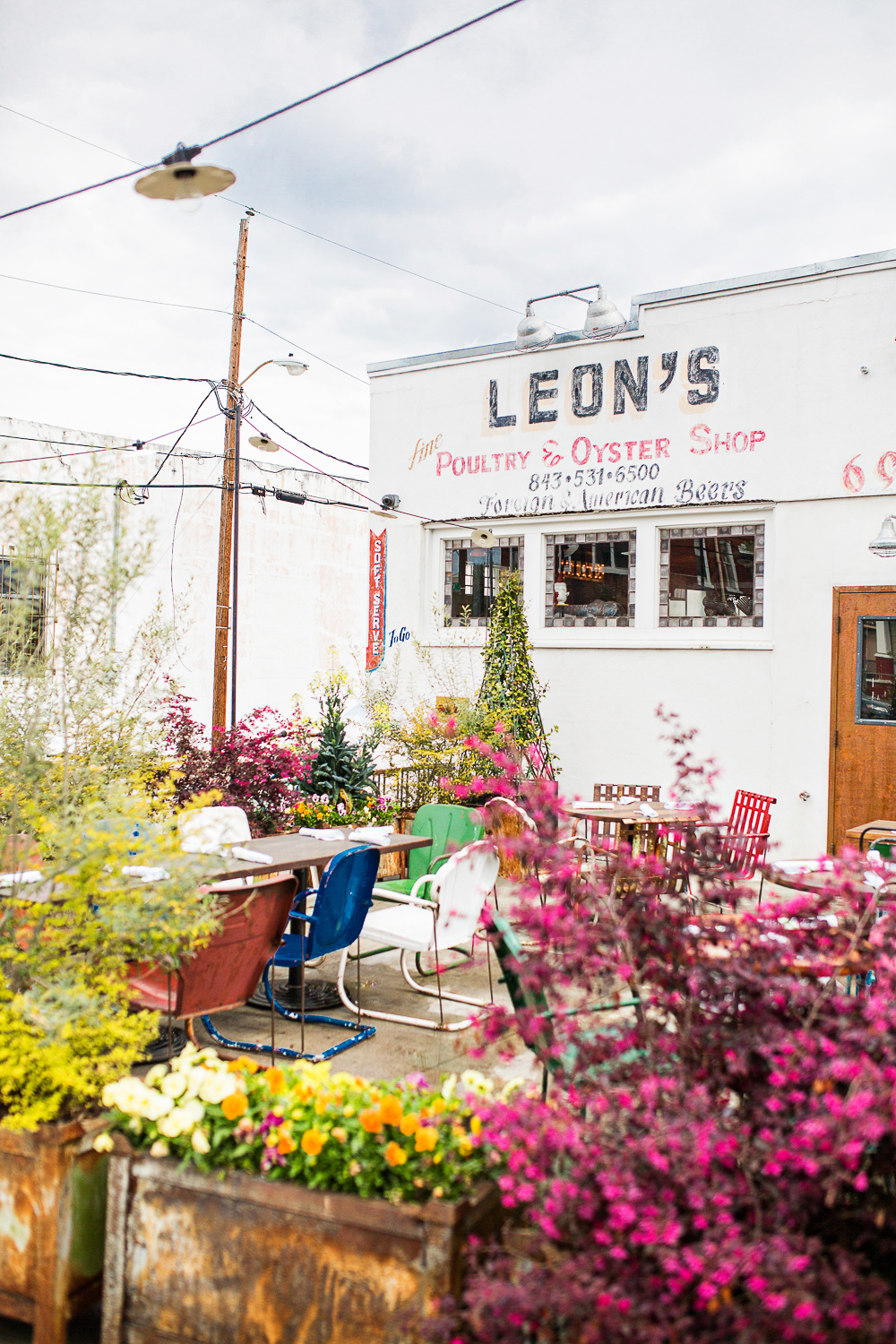 The exterior of Leons Oyster shop with plenty of growing flowers in Downtown Charleston