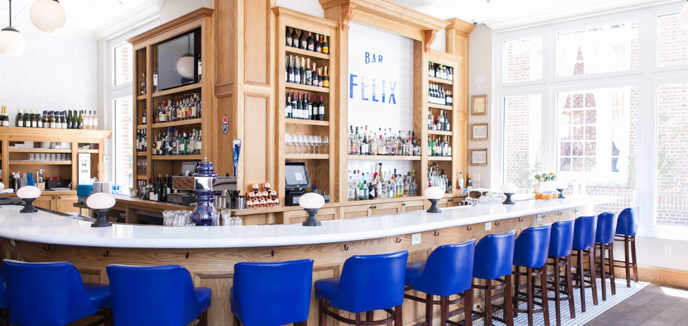 Felix Interior shot of their cocktail bar with deep blue chairs lining the counter