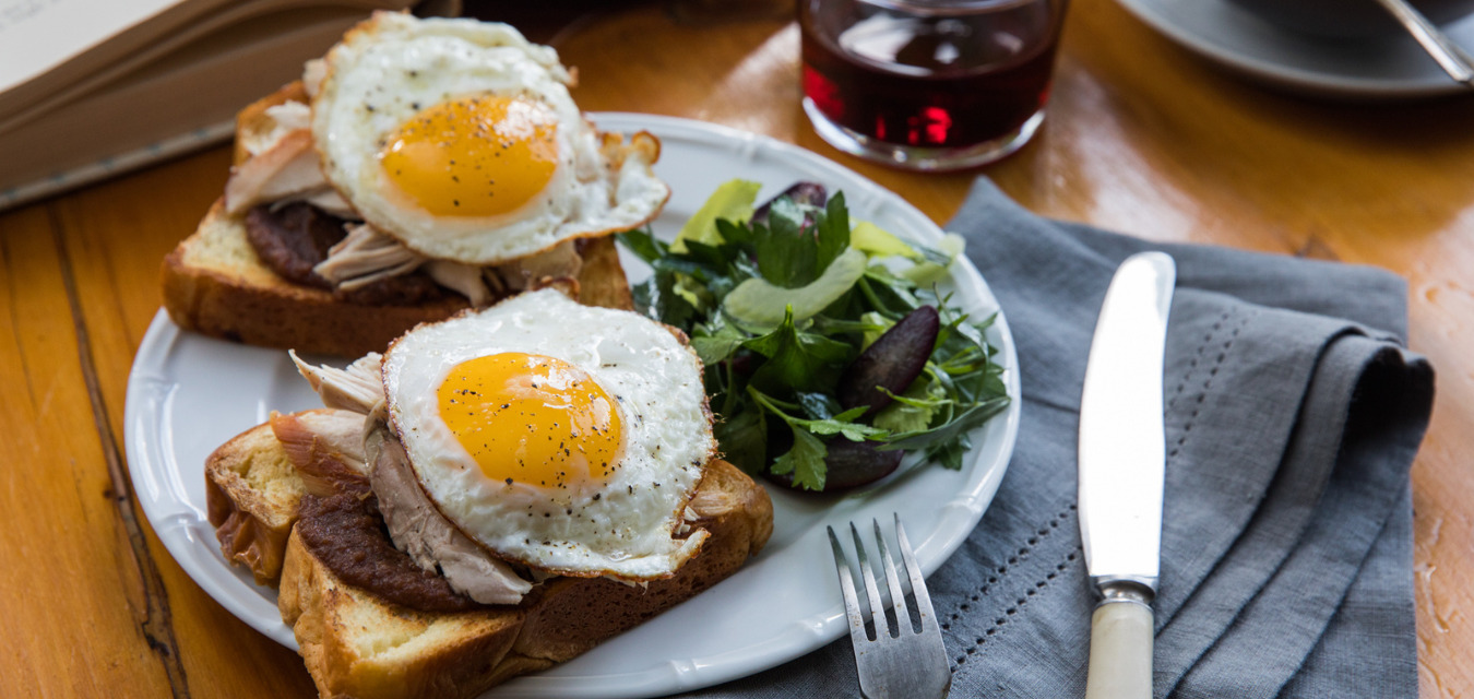 Brunch recipes by Cheryl Day featured image: eggs on toast with a side of greens and wine