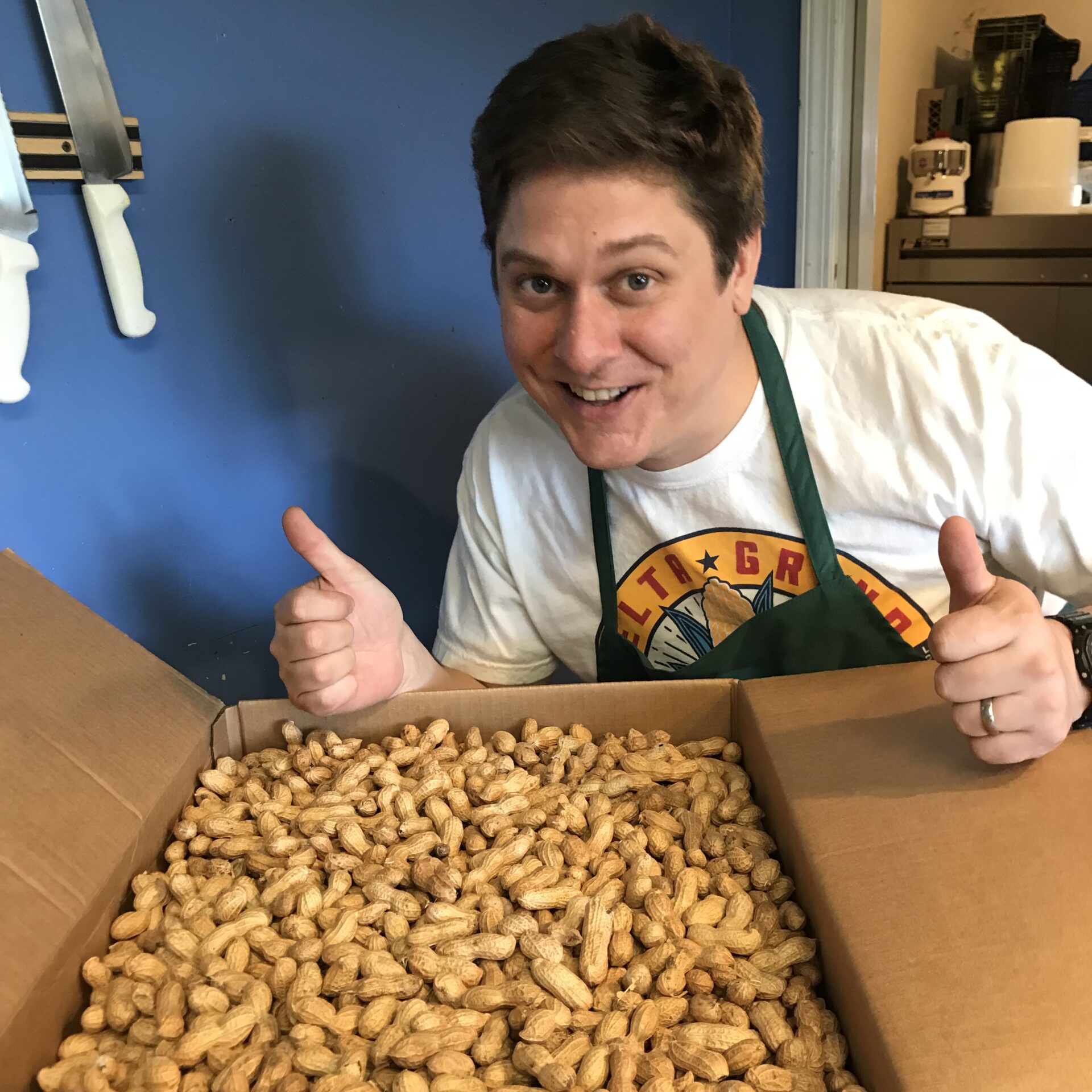 man behind a large tray of boiled peanuts