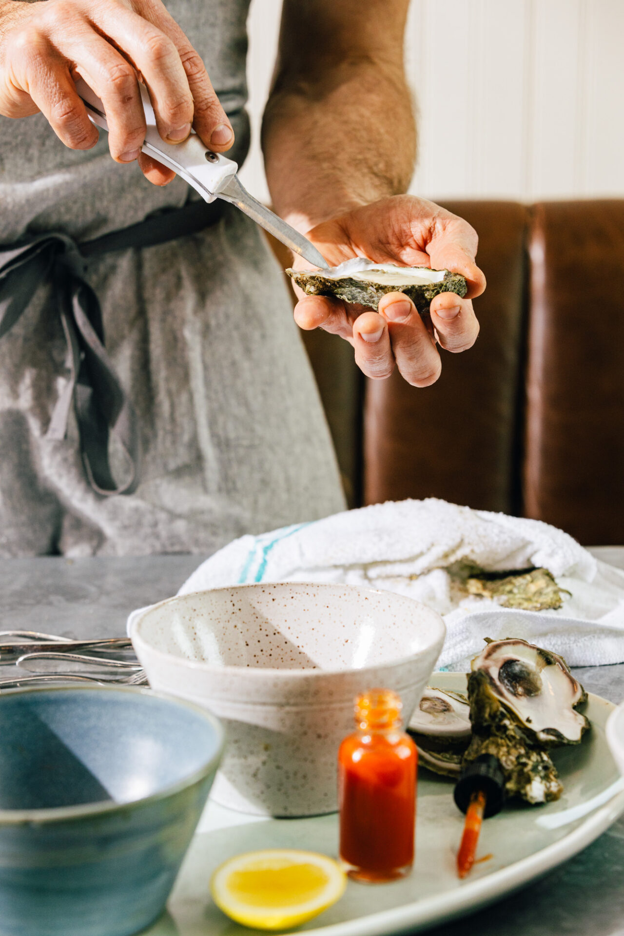 A man serves oysters with hot sauce