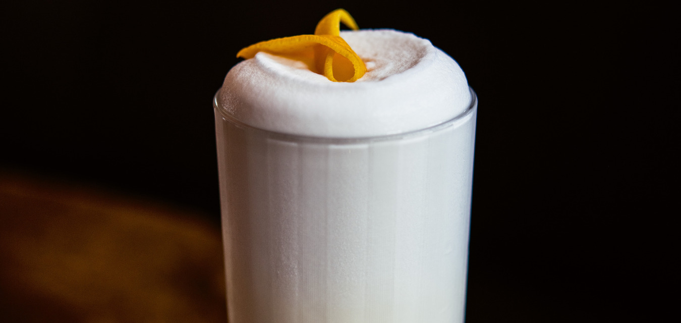 Ramos Gin fizz with an orange twist in a highball glass at Cure