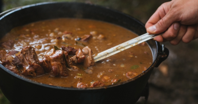 Lafayette, Louisianal: An image of a big bowl of brown gumbo and stew with a metal spoon in it from the Blackpot Festival Cookoff.