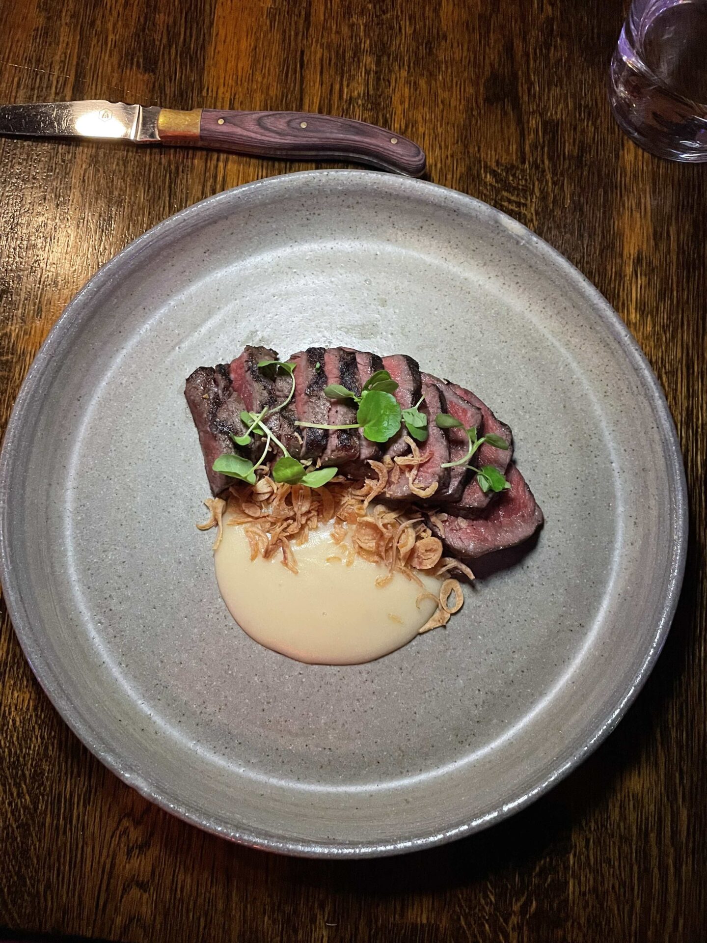 Strip Loin Steak with potato puree on a plate at MACHETE