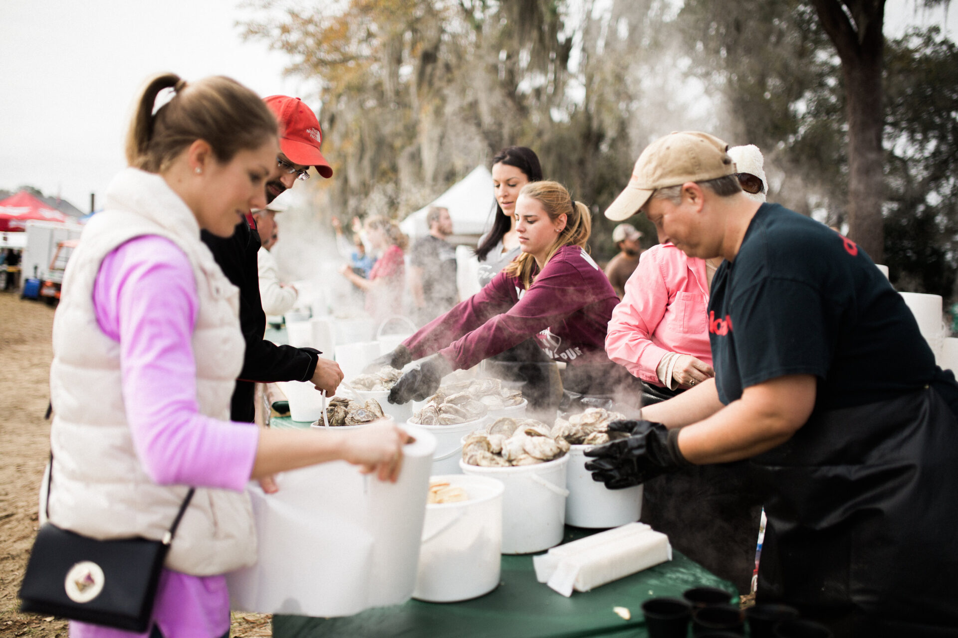 A group of people shucking oysters at the oyster festival