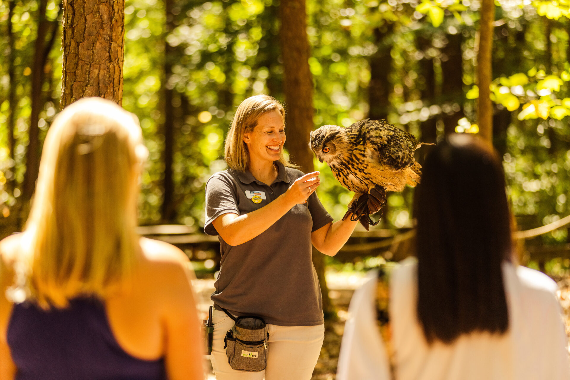 A caretaker at the Carolina Raptor Center holding a large owl during a presentation. 